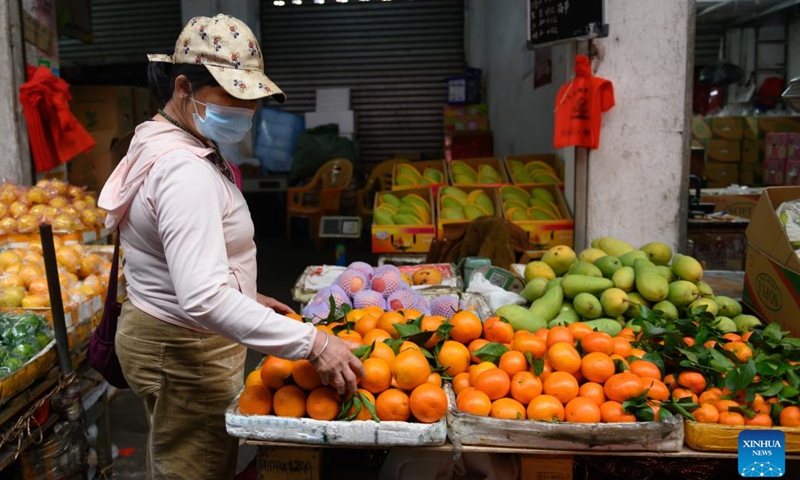 A vendor arranges fruits at a local market in Haikou, south China's Hainan Province, March 8, 2022. (Photo: Xinhua)