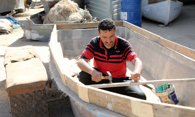 The owner of a boat-building workshop works on a new boat in Baghdad, Iraq, on March 4, 2022.(Photo: Xinhua)