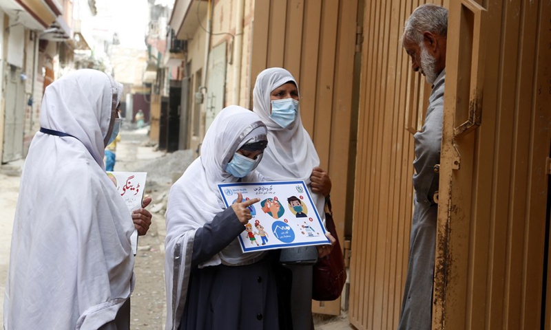 Female health workers brief a resident about COVID-19 during a door-to-door health service camping on the outskirts of Islamabad, capital of Pakistan, on March 8, 2022.(Photo: Xinhua)