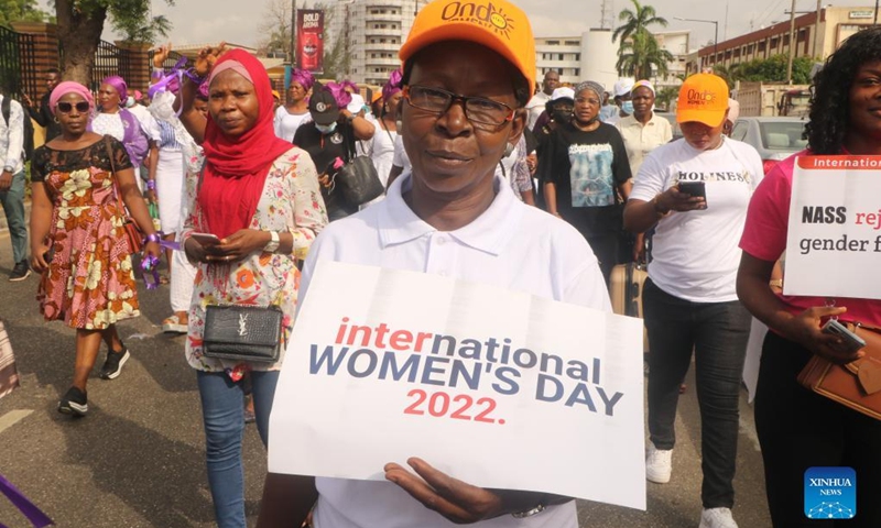 A woman shows a poster during a gathering celebrating the International Women's Day in Lagos, Nigeria, March 8, 2022.(Photo: Xinhua)