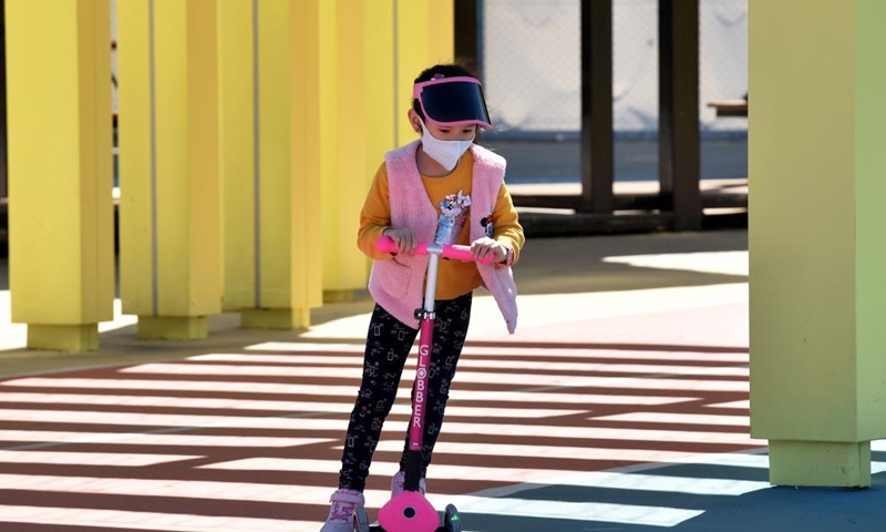 A girl wearing a face mask plays at a park in Hong Kong, south China, March 8, 2022. The Hong Kong Special Administrative Region (HKSAR) reported 28,475 new COVID-19 cases on March 8. (Xinhua/Lo Ping Fai)