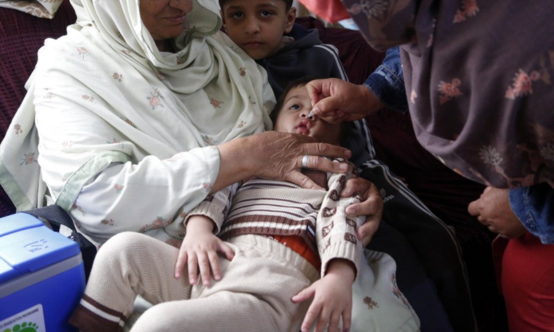 A female health worker administrates polio-vaccine drops to a child during a door-to-door health service camping on the outskirts of Islamabad, capital of Pakistan, on March 8, 2022.(Photo: Xinhua)
