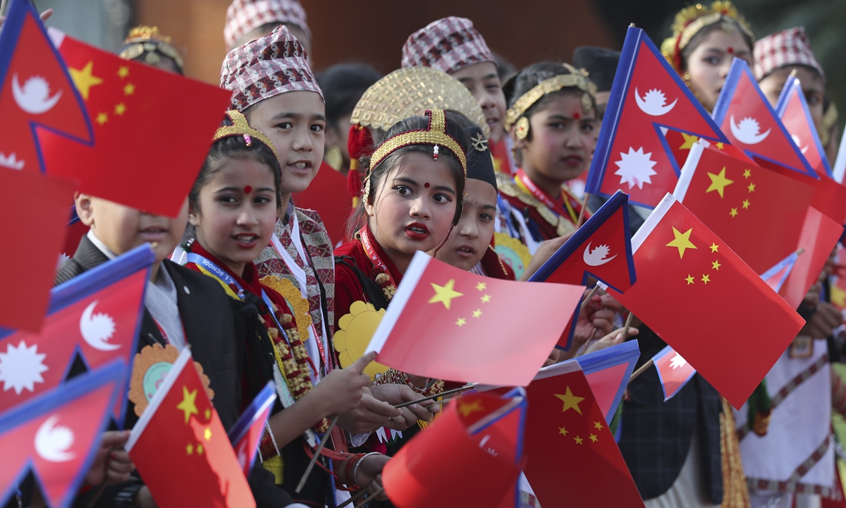 Nepalese children wave national flags of China and Nepal to welcome Chinese President Xi Jinping for a state visit in Nepal in October 2019. 
Photo: cnsphoto