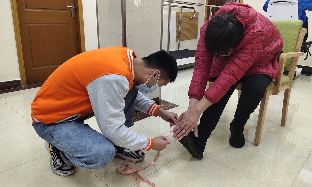 A Shanghai University of Sport student helps a resident with disability do a simple physical examination at a fitness center at Changqiao subdistrict in Shanghai. Photo: Courtesy of Zhang Mingkai 