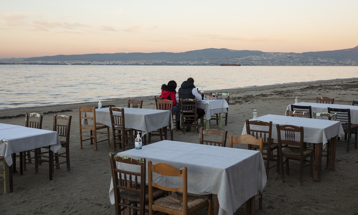 A couple have lunch on the beach at an empty seaside restaurant in the eastern suburb of Peraia in Thessaloniki, Greece, on December 1, 2021. Photo: VCG