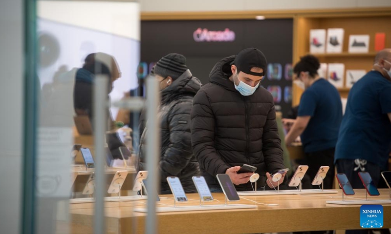 A person looks at a smartphone at an Apple store in New York, the United States, on March 10, 2022. US consumer inflation in February continued to rise at the fastest annual pace in 40 years, the US Labor Department reported on Thursday.