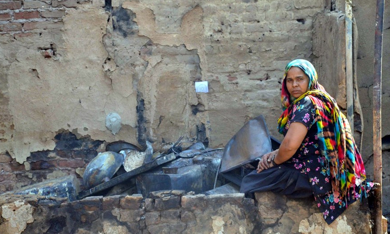 A woman sits outside a burnt residential hut after a major fire broke out near Gokalpur village in northeast Delhi, India, March 12, 2022.Photo:Xinhua