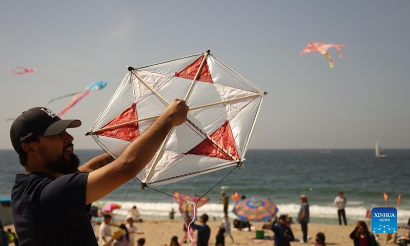 A man flies a kite at the Redondo Beach in Los Angeles, California, the United States on March 13, 2022. Thousands of people on Sunday gathered at the Redondo Beach Pier in Los Angeles for its 48th Annual Festival of the Kite. (Photo by Zeng Hui/Xinhua)