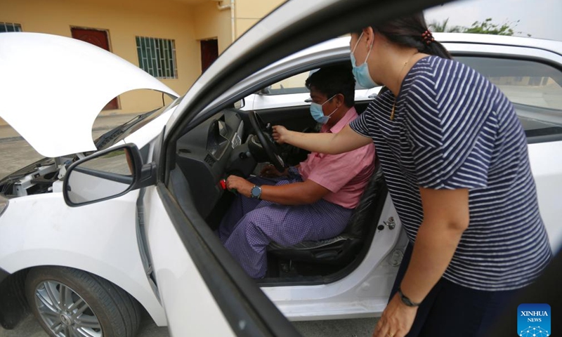 A customer examines a hybrid electric car KSDV1-NE2 at the Khaingkhaing Sangda Motorcar Development Center in Yangon, Myanmar, March 9, 2022.Photo:Xinhua
