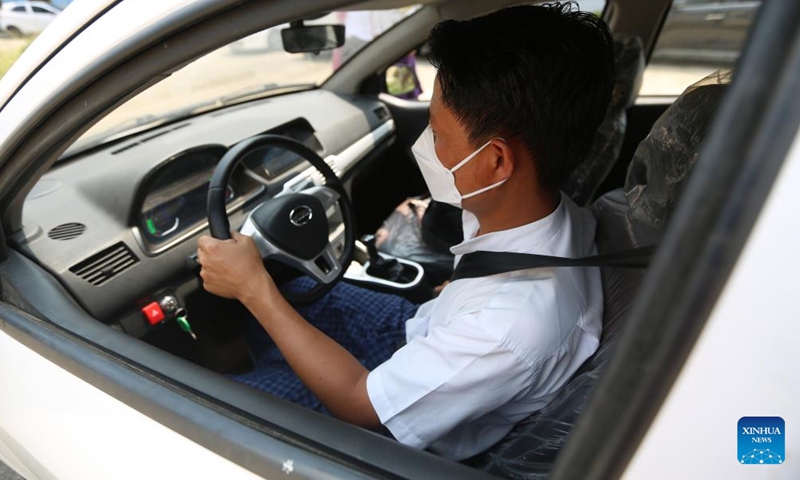 A man tries a hybrid electric car KSDV1-NE2 at the Khaingkhaing Sangda Motorcar Development Center in Yangon, Myanmar, March 9, 2022.Photo:Xinhua