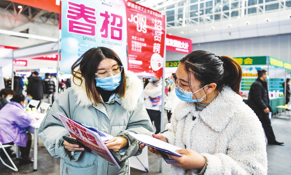A job applicant exchanges information with a recruiter at a spring job fair held in Urumqi,Northwest China's Xinjiang Uygur Autonomous Region on Feburary 26, 2022. The fair hosted more than 200 enterprises with 2,000 positions available. Photo: cnsphoto 