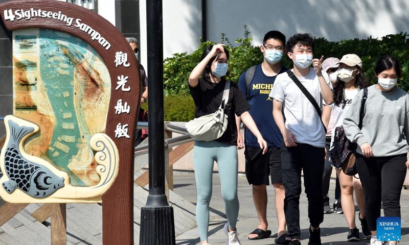 People wearing masks walk on the street in south China's Hong Kong, March 13, 2022.Photo:Xinhua