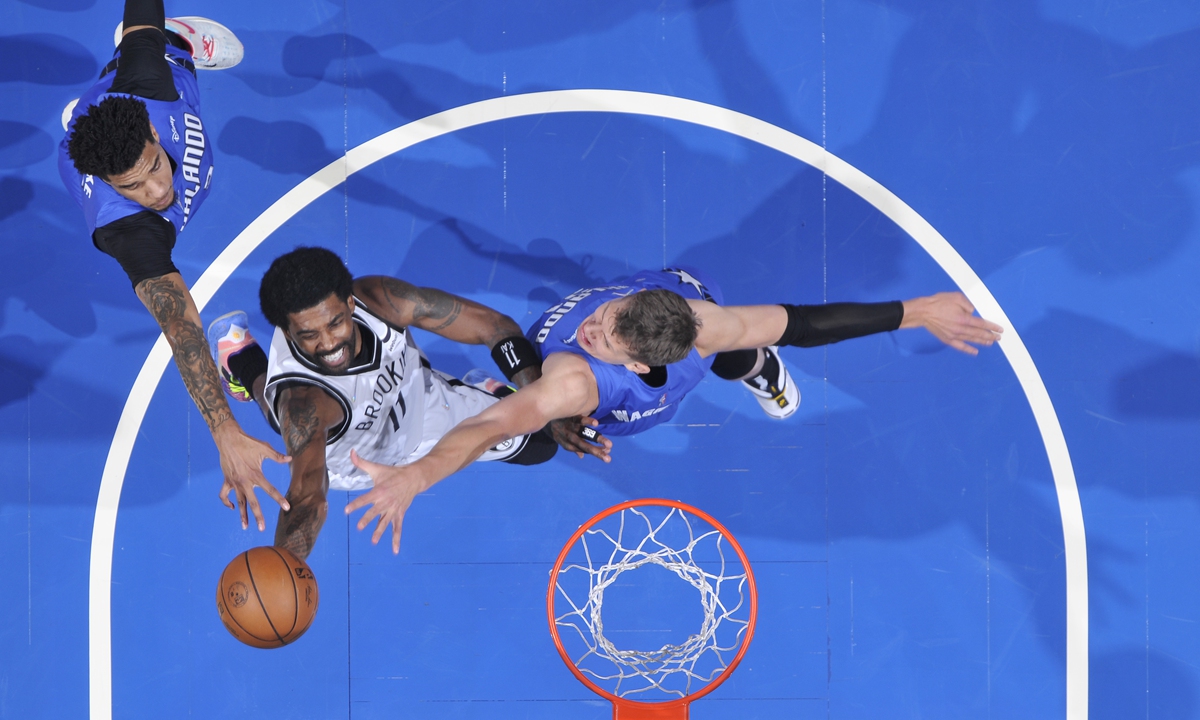 Kyrie Irving (center) of the Brooklyn Nets drives to the basket against the Orlando Magic on March 15, 2022 in Orlando, Florida. Photo: VCG