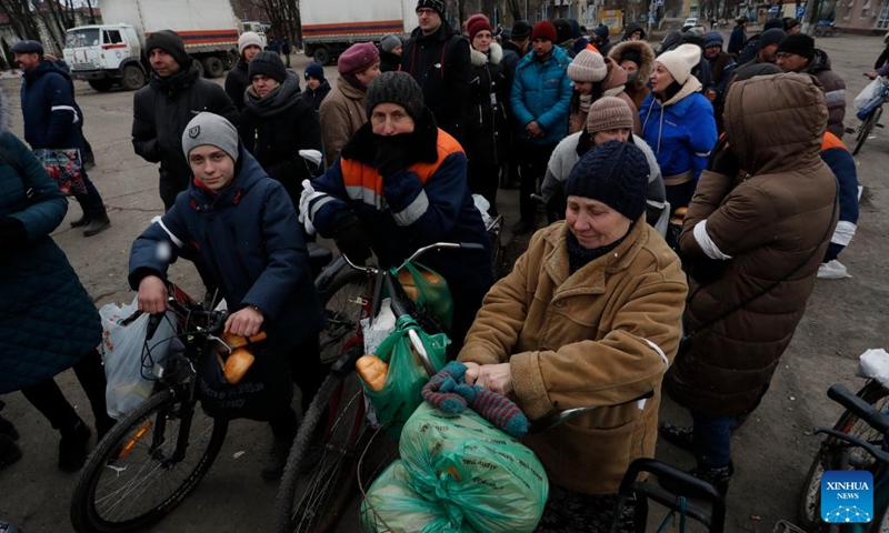 Local residents queue up to receive humanitarian aid in Volnovakha of Donetsk, March 15, 2022. (Photo by Victor/Xinhua)