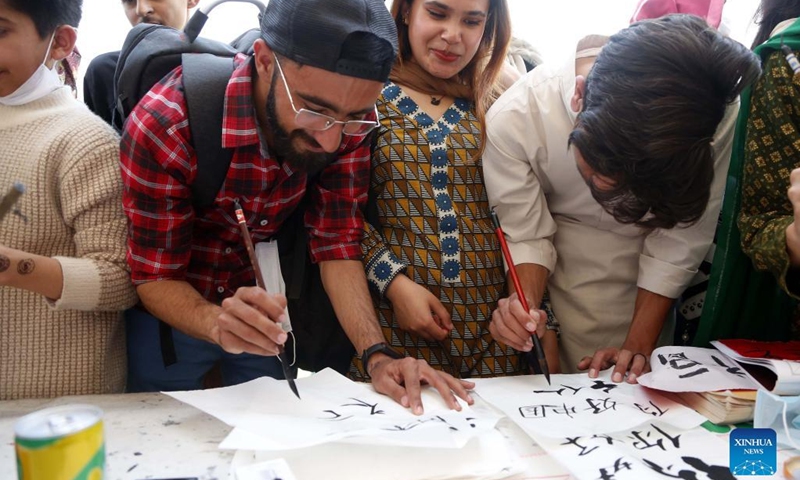 Students learn to write Chinese calligraphy during an international cultural festival at the National University of Modern Languages (NUML) in Islamabad, capital of Pakistan on March 14, 2022. (Photo: Xinhua)