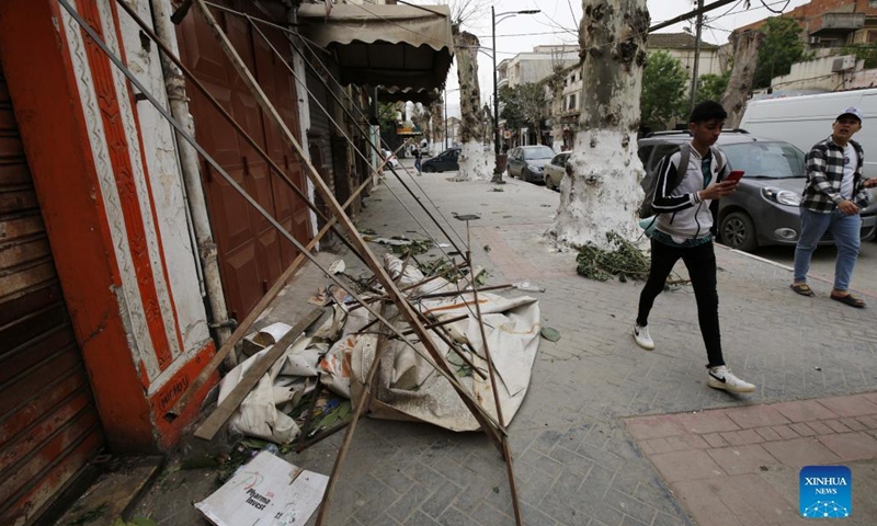 People walk past a store damaged in strong winds in Algiers, Algeria, on March 15, 2022. Algeria has experienced squally winds since March 14, which damaged houses, uprooted trees and disrupted air and rail transport.(Photo: Xinhua)