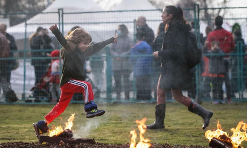 A child leaps over a bonfire during the Fire Festival at Ambleside Park in West Vancouver, British Columbia, Canada, March 15, 2022. Fire Festival is celebrated by Iranians on the eve of the last Wednesday before Nowruz, the Iranian new year. (Photo by Liang Sen/Xinhua)