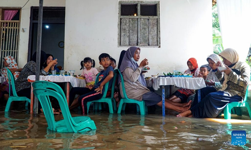 People attend a wedding ceremony in flood water in Cilacap, Central Java, Indonesia, March 16, 2022. (Photo: Xinhua)