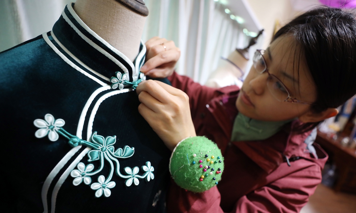 A designer stitches a qipao in her studio in East China's Shandong Province on April 10, 2019.Photo: IC