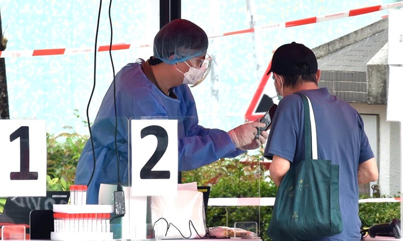 A medical worker helps a citizen register for COVID-19 nucleic acid test at a mobile testing site in Hong Kong, south China, March 16, 2022. On Wednesday, Hong Kong registered 14,454 new COVID-19 cases by nucleic acid tests, and 14,818 additional positive cases through self-reported rapid antigen tests, official data showed.(Photo: Xinhua)