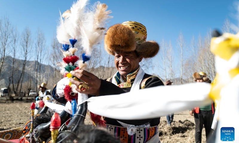 A villager arranges the decoration of a tractor at a ceremony marking the start of spring farming in Carbanang Village, Quxu County of Lhasa, southwest China's Tibet Autonomous Region, March 16, 2022. The annual spring farming ceremony was held in Tibet on Wednesday to pray for a bumper harvest of the year.(Photo: Xinhua)
