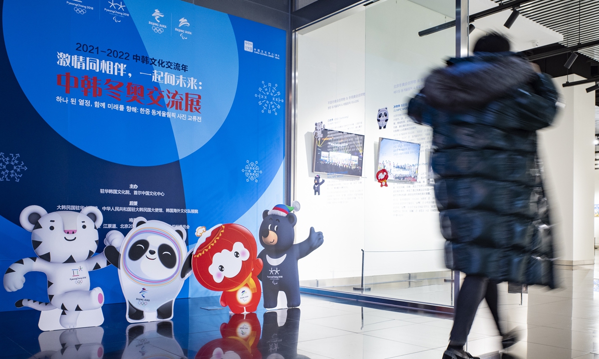 A person walks past the exhibition between China and South Korea in Beijing featuring mascots from the Pyeongchang 2018 and Beijing 2022 Olympic Winter Games on January 27, 2022. 
Photo: VCG
