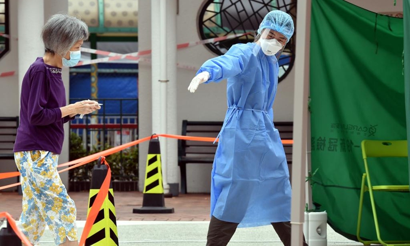A medical worker guides a citizen at a mobile nucleic acid testing site in Hong Kong, south China, March 16, 2022. On Wednesday, Hong Kong registered 14,454 new COVID-19 cases by nucleic acid tests, and 14,818 additional positive cases through self-reported rapid antigen tests, official data showed.(Photo: Xinhua)