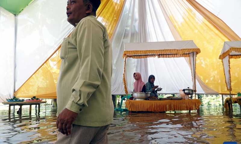 People attend a wedding ceremony in flood water in Cilacap, Central Java, Indonesia, March 16, 2022. (Photo: Xinhua)