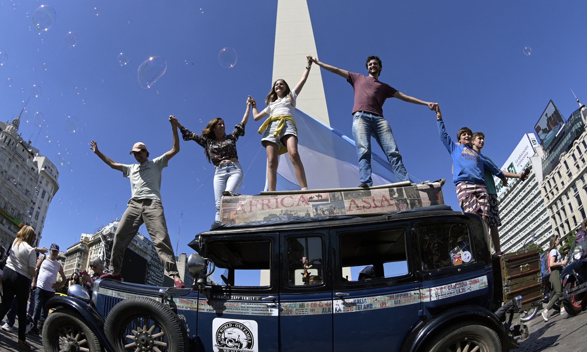 Argentinian Zapp family waves on top of its car at Republica square in Buenos Aires, on March 13, 2022 after finishing a 22-year journey around the world. Photo: AFP 