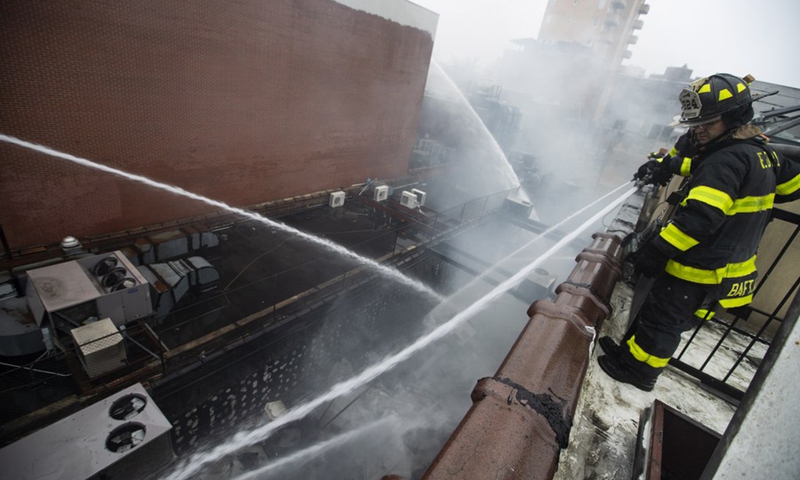 Fire fighters work to extinguish the fire at a commercial building in Flushing of New York, the United States, March 17, 2022.(Photo: Xinhua)