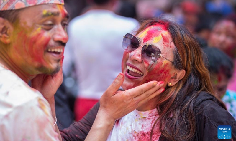 People smear colored powder on each other to celebrate Holi, the festival of colors, in Lalitpur, Nepal, March 17, 2022.(Photo: Xinhua)