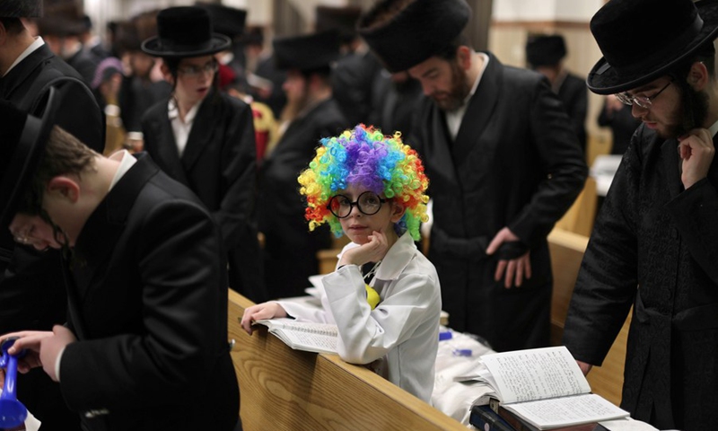 An ultra-Orthodox child wearing costume for Purim attends a reading of the Megillat Esther during the Jewish holiday of Purim at a synagogue in Ashdod, southern Israel, on March 16, 2022.(Photo: Xinhua)
