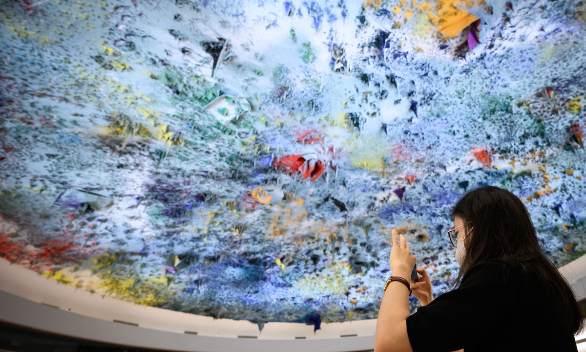 A woman takes a picture during a session on the UN Human Rights Council in Geneva, on September 13, 2021. Photo: CFP