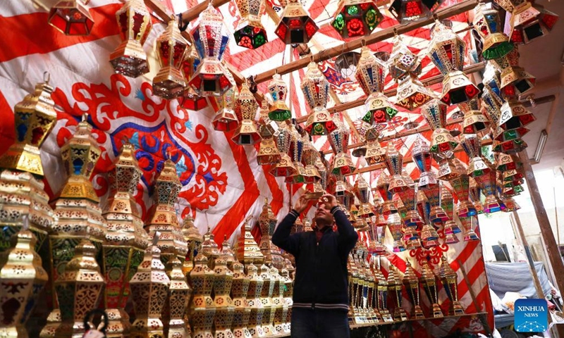 A man takes photos of lanterns ahead of the holy month of Ramadan at a market in Cairo, Egypt, on March 18, 2022.Photo:Xinhua