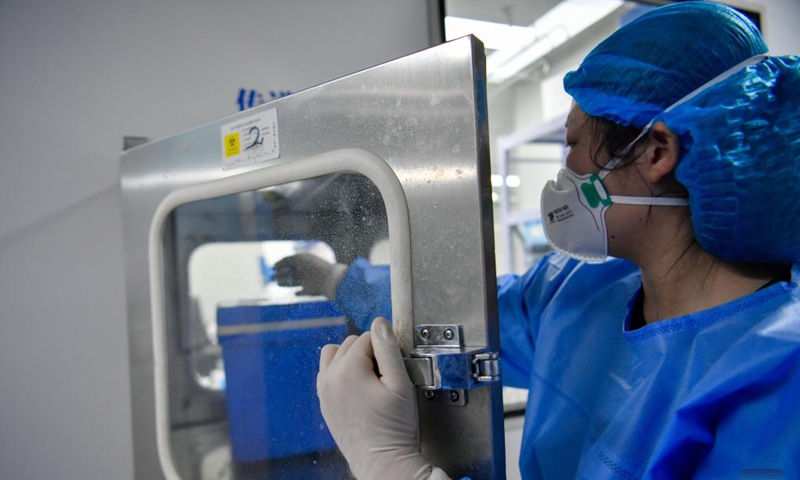 A staff member transfers a box containing nucleic acid test samples at a nucleic testing base in Hebei District of Tianjin, north China, March 19, 2022. Photo:Xinhua 