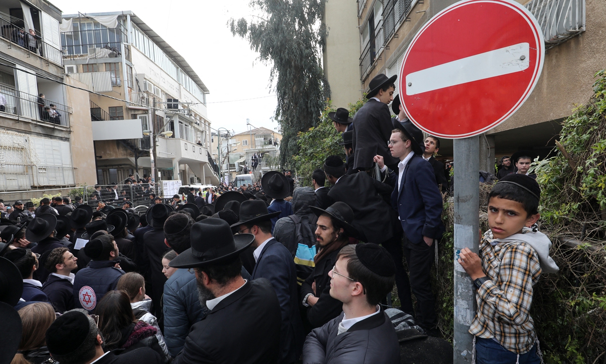 Ultra-Orthodox Jewish men and children gather outside the home of late rabbi Chaim Kanievsky, ahead of his funeral in the Israeli city of Bnei Brak near Tel Aviv, on March 20, 2022. Kanievsky, 94, a key figure among the ultra-Orthodox Jewish community, died in Israel on March 18, 2022. Photo: AFP