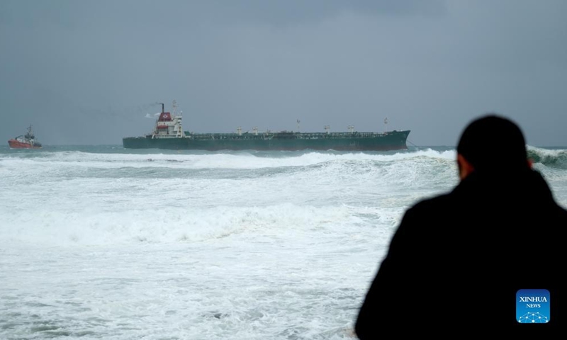 People watch a chemical tanker off the Bahar ic-Caghaq coast, Naxxar, Malta, on March 19, 2022.Photo:Xinhua