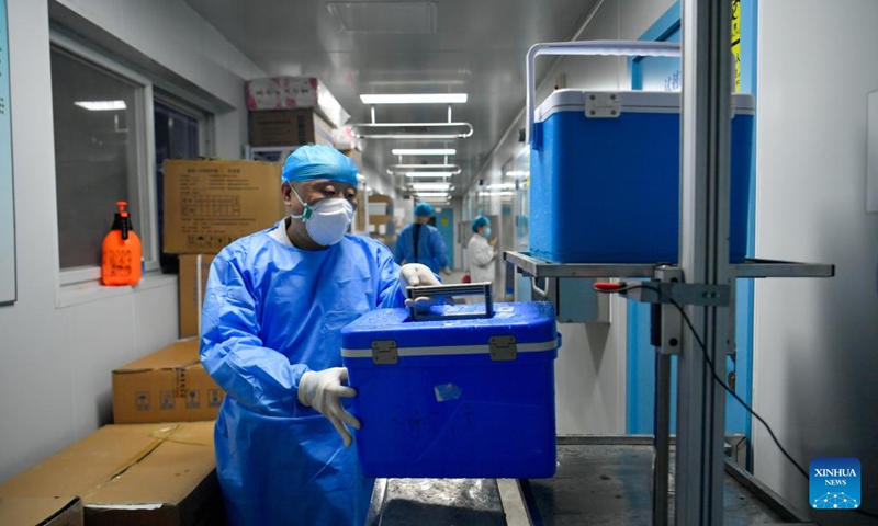 A staff member transfers a box containing nucleic acid test samples at a nucleic testing base in Hebei District of Tianjin, north China, March 19, 2022. Photo:Xinhua 