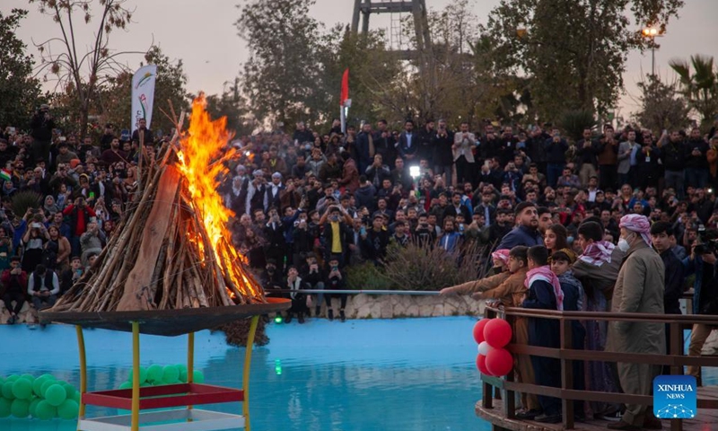 People gather around a bonfire during a Newroz celebration in Erbil, Iraq, on March 20, 2022.Photo:Xinhua