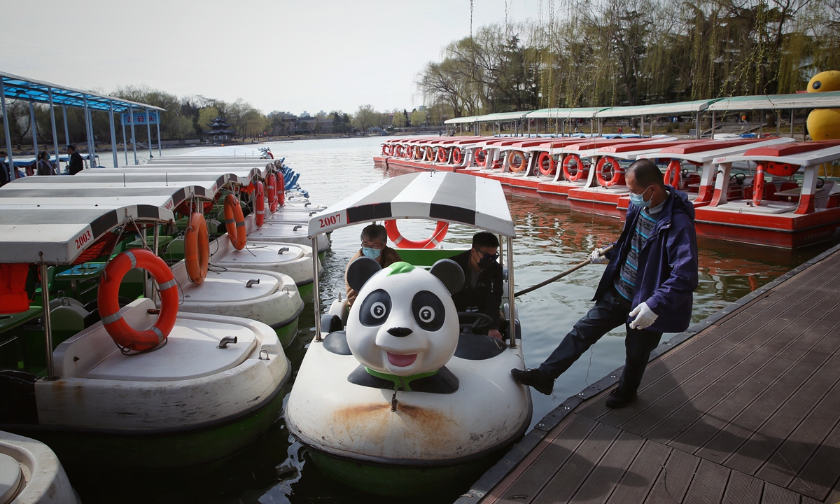 A worker in Taoranting Park in Beijing pulls a boat onto the dock on March 21, 2022. The tourist boats in five parks in Beijing, including Taoranting, are all equipped with 5G and the BeiDou Navigation Satellite System.Photo:IC