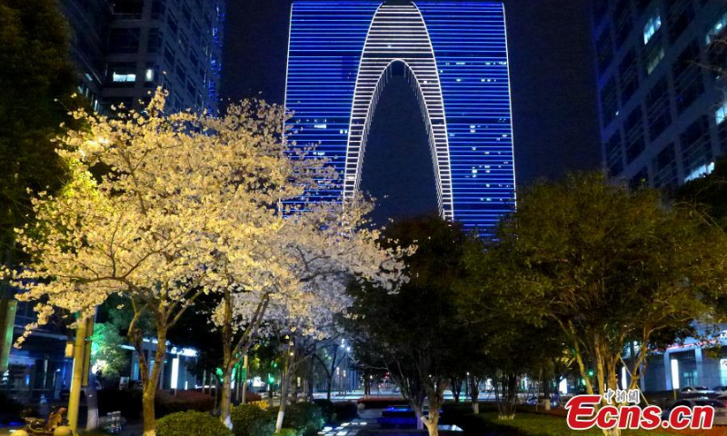 Cherry blossoms and Suzhou's landmark building, the Gate of the East, create a beautiful night view in Suzhou, east China's Jiangsu Province, March 22, 2022. (Photo provided to China News Service)