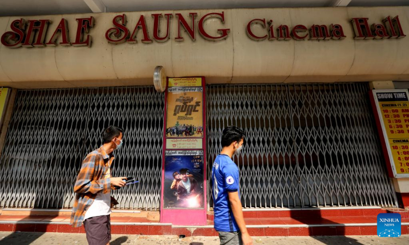 People walk past the shuttered Thamada Cinema in downtown Yangon, Myanmar, on March 24, 2022. Myanmar's Ministry of Information has announced to reopen about 60 movie theaters in the country starting on April 17, in accordance with Health Ministry's COVID-19 prevention and control measures. (Xinhua/U Aung)