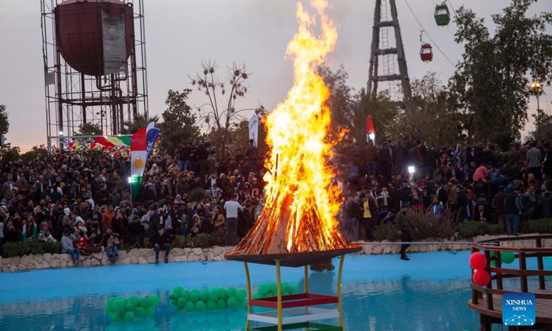 People gather around a bonfire during a Newroz celebration in Erbil, Iraq, on March 20, 2022.Photo:Xinhua