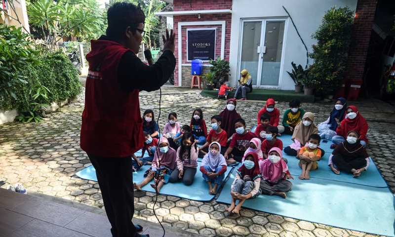 A volunteer tells stories for children on World Storytelling Day in Kampong Dongeng community in Indonesia's Banten Province on March 20, 2022.Photo:Xinhua
