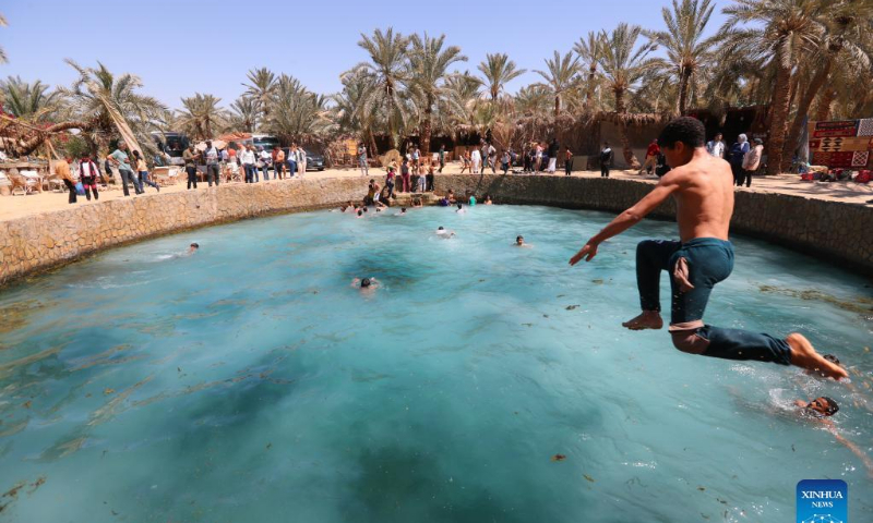 A boy dives into the Cleopatra's Pool at Siwa Oasis in Matrouh Governorate, Egypt, on March 26, 2022. Siwa Oasis lies in Egypt's western desert and there are some 2,000 natural hot springs in which locals love taking a bath. Photo: Xinhua