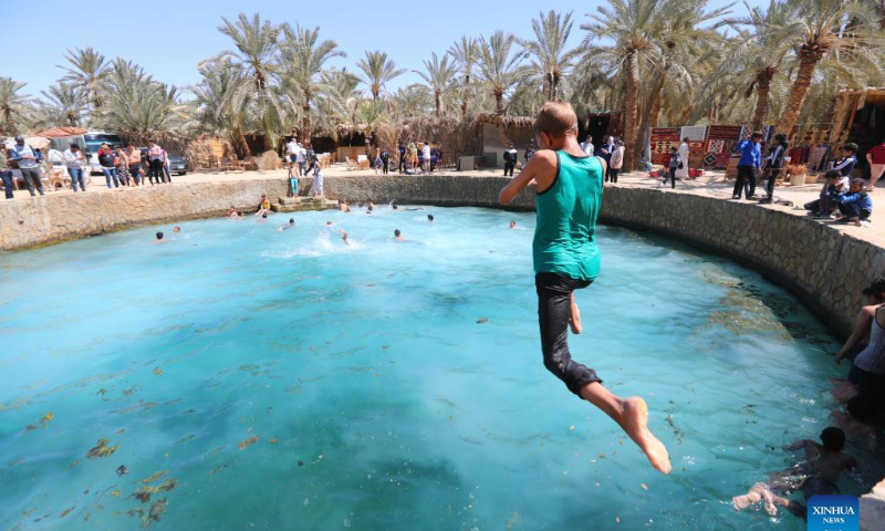 A boy dives into the Cleopatra's Pool at Siwa Oasis in Matrouh Governorate, Egypt, on March 26, 2022. Siwa Oasis lies in Egypt's western desert and there are some 2,000 natural hot springs in which locals love taking a bath. Photo: Xinhua
