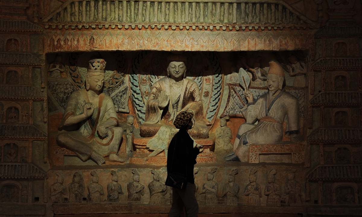 A visitor observes a 3D-printed replica of the Yungang Grottoes in Hangzhou, East China's Zhejiang Province on March 22, 2022. The Zhejiang Art Museum has brought China's grottoes to Hangzhou with 3D printing technology, including the Mogao, Yungang, Longmen and Anyue grottoes. Photo: IC