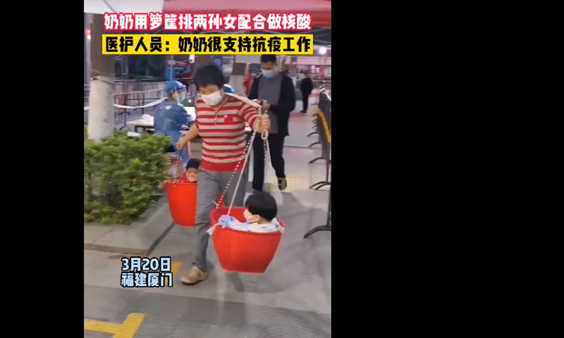 Grandma carries kids on carrying pole for COVID-19 testing. Screenshot of Bailu Video