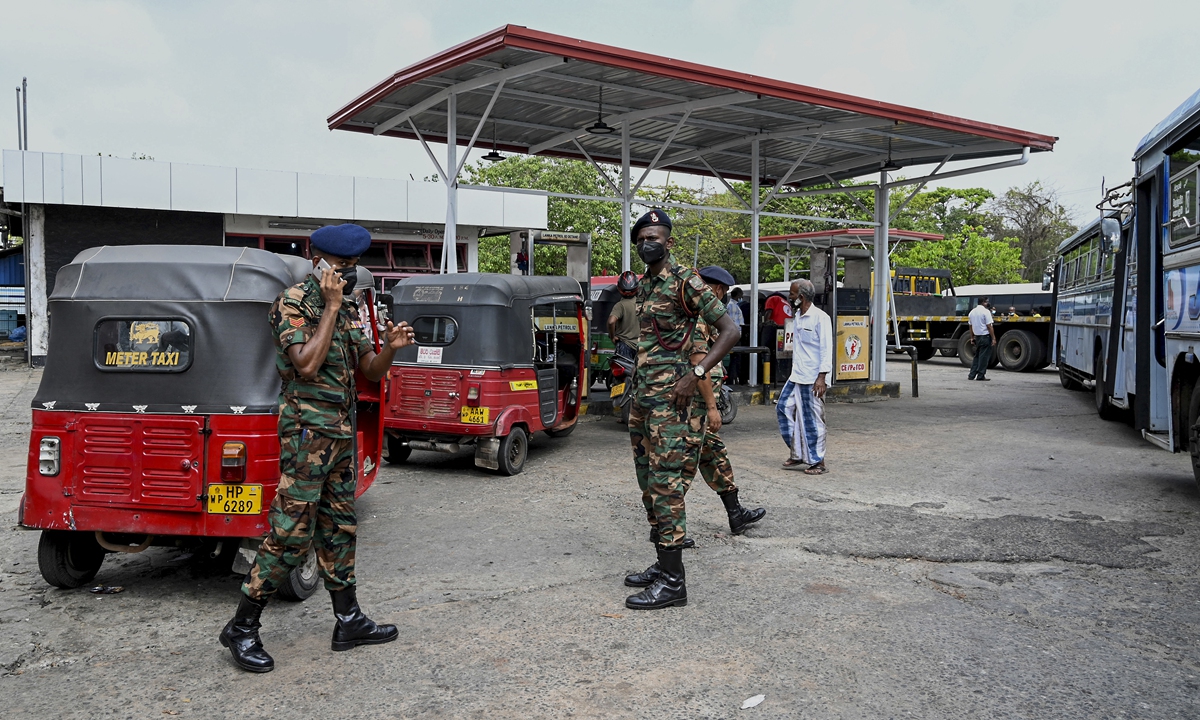 Soldiers guard a fuel station in Colombo on March 22, 2022. Sri Lanka ordered troops to petrol stations as sporadic protests erupted among the thousands of motorists queueing up daily for scarce fuel. The decision to position troops near petrol pumps and kerosene supply points came after three elderly people dropped dead during their wait in long queues, Reuters said. Photo: AFP