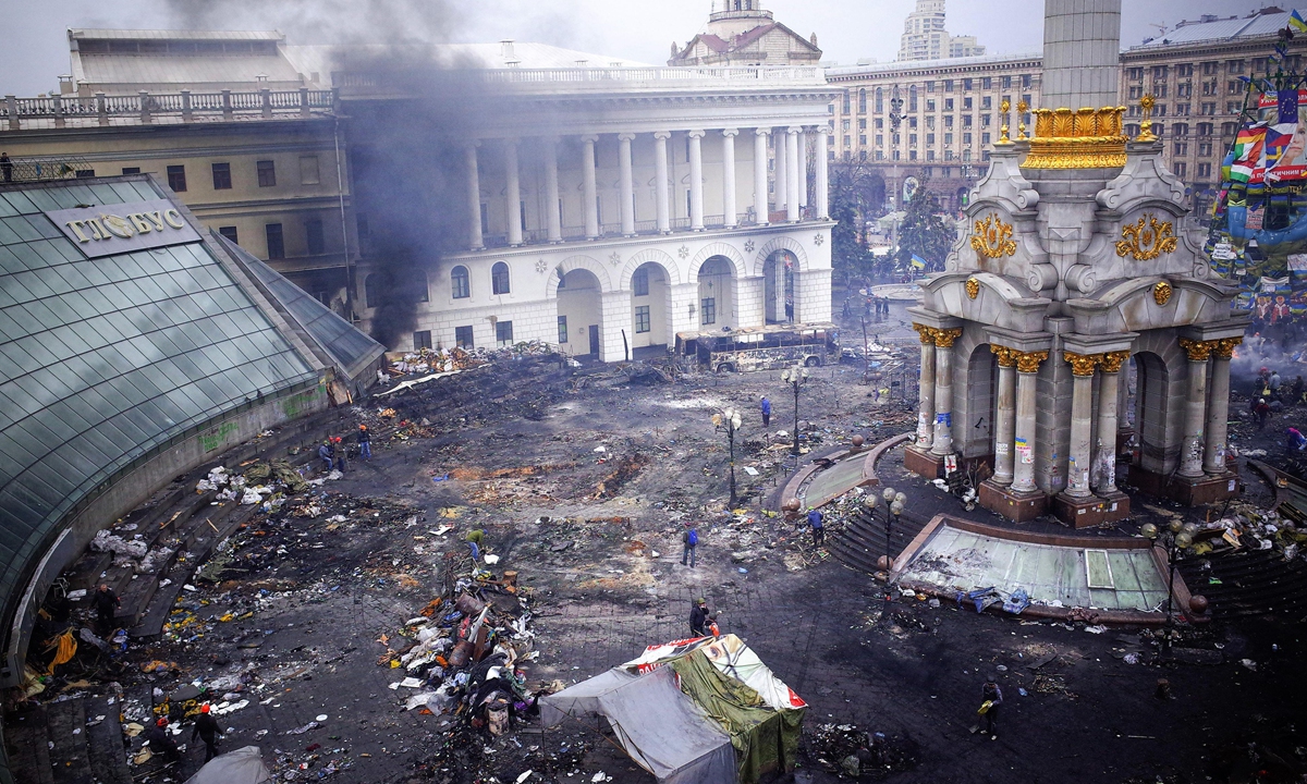 Locals inspect damage caused by anti-government protests, part of US-backed movement against the country's pro-Russia government,in Independence Square in Kiev, Ukraine, on February 20, 2014. Photo: VCG